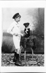 Photographie studio montrant un enfant avec son chien ratier en noeud papillon fumant la pipe  - 1910