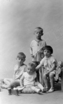 Une fratrie pose en studio avec des jouets.  - Paris (75)  - 1935