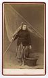 Portrait en studio d'une femme de marin en costume traditionnel avec son filet et son panier  - Calais (59)  - 1865