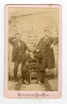 Photographie de trois hommes posant en extérieur devant une affiche de liqueur  - Soissons (2)  - 1865