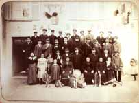 Partie de la fanfare qui pose avec femmes et enfants devant le café 'bal du progrès'  - Longvilliers (95)  - 1905