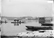 Lors d'une inondation, une famille et un chien sont dans une barque au milieu des maisons de banlieue inond�es, avec de la neige sur les toits  - Paris (75)  - 1910