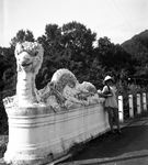 Une petite fille d'un colon pose  ct d'un dragon sculpt sur un pont  - Viet Nam (Hano)  - 1932