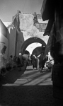 Dans une ville tunisienne, une rue dans un quartier arabe avec au loin une mosque  - Tunisie - 1938