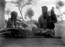 Des musiciens posent avec leurs instruments en fumant le narguilé  - Tunisie - 1910