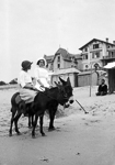 Deux jeunes filles en promenade sur un �ne sur la plage de la Baule.  - La Baule-Escoublac (44)  - 1910