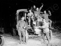 Des militaires dans le garage d'une caserne posent un vieux camion de la première guerre mondiale.  - 1925