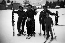 Trois chasseurs alpins posent avec des enfants voulant faire du ski dans la station  - Autriche - 1952